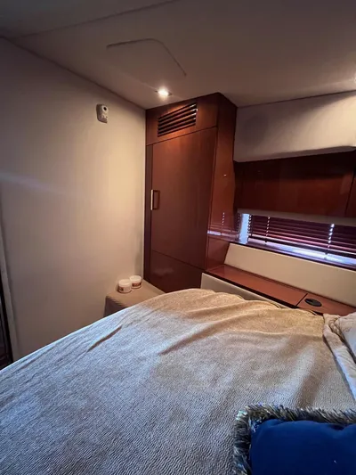 Zingaro Yacht Photos Pics Interior cabin of 2013 Sea Ray 450 Sundancer with wooden cabinetry and cozy bedding.