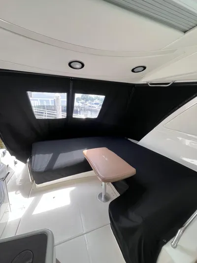 Zingaro Yacht Photos Pics Interior of 2013 Sea Ray 450 Sundancer yacht with black seating and table.