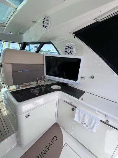 Zingaro Yacht Photos Pics Interior of 2013 Sea Ray 450 Sundancer yacht with TV and kitchenette.