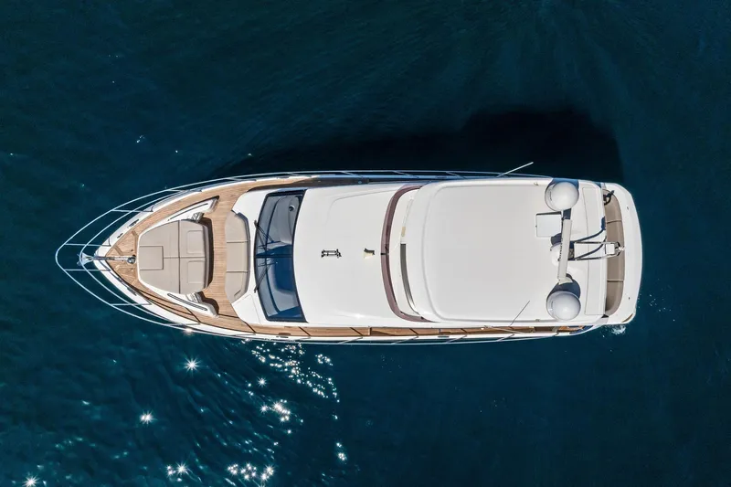 Salty Cowboy Yacht Photos Pics Aerial view of 2022 Princess 55 Flybridge yacht on calm blue water.