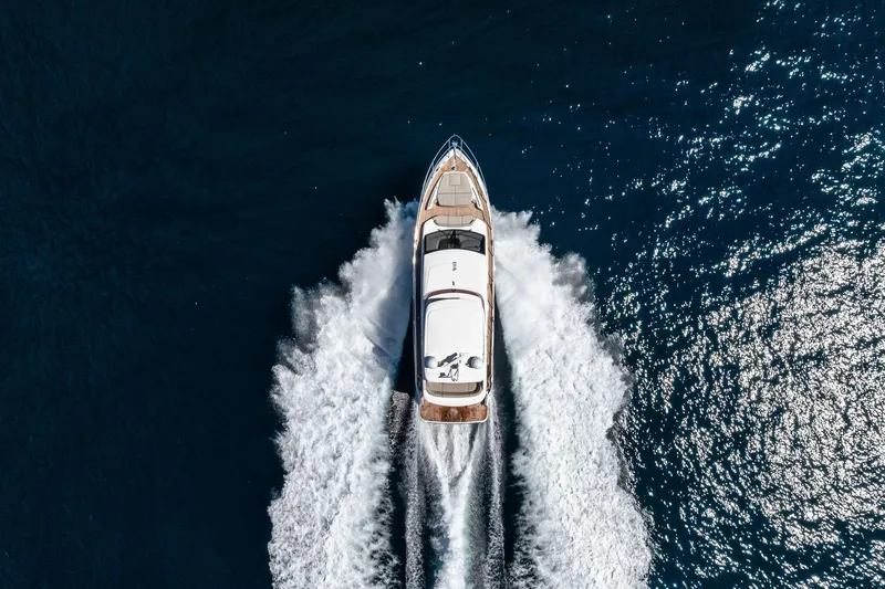 Salty Cowboy Yacht Photos Pics Aerial view of 2022 Princess 55 Flybridge yacht cruising on open water.