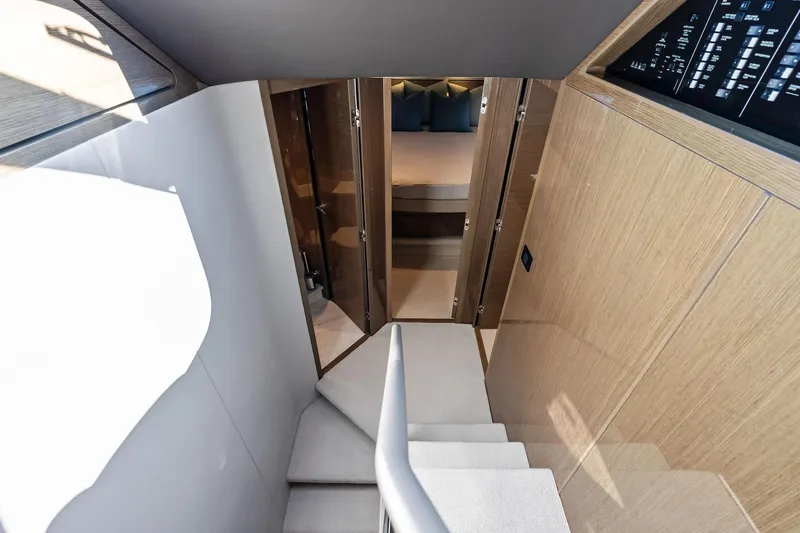 Salty Cowboy Yacht Photos Pics Interior view of 2022 Princess 55 Flybridge yacht, featuring stairs and a cozy bedroom.