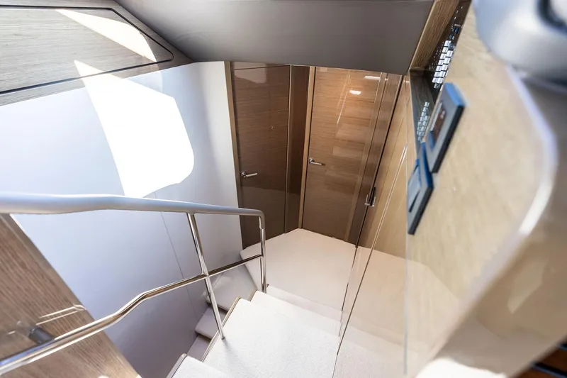 Salty Cowboy Yacht Photos Pics Staircase inside 2022 Princess 55 Flybridge yacht with sleek wooden finish and modern design.