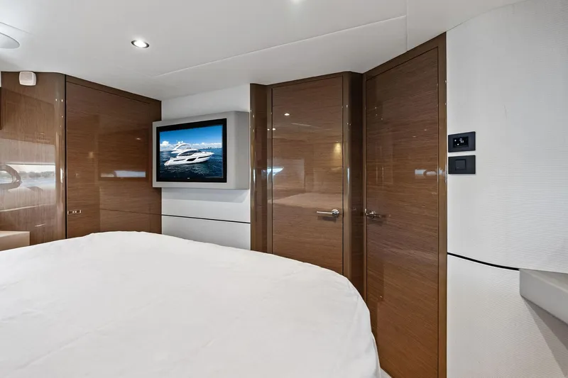 Salty Cowboy Yacht Photos Pics Luxurious interior of 2022 Princess 55 Flybridge yacht with modern wood paneling and TV.