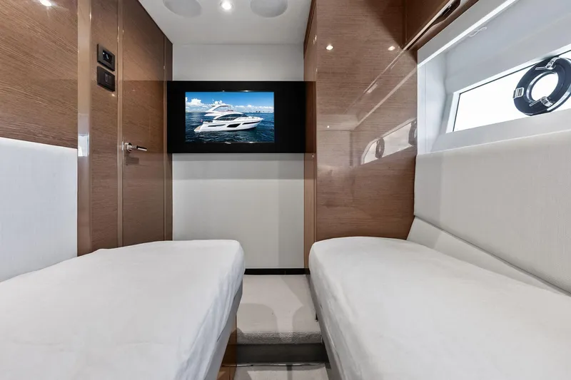 Salty Cowboy Yacht Photos Pics Luxurious interior of 2022 Princess 55 Flybridge yacht with twin beds and wall-mounted TV.