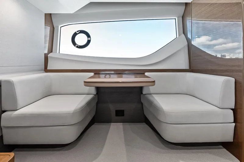 Salty Cowboy Yacht Photos Pics Luxurious interior of 2022 Princess 55 Flybridge yacht with elegant seating and large window.