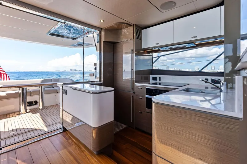 Salty Cowboy Yacht Photos Pics Luxurious interior of 2022 Princess 55 Flybridge yacht with modern kitchen and ocean view.