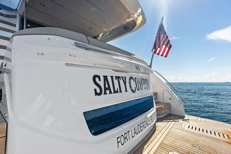 Salty Cowboy Yacht Photos Pics Luxury Princess 55 Flybridge yacht, 2022 model, docked with American flag, ocean view.