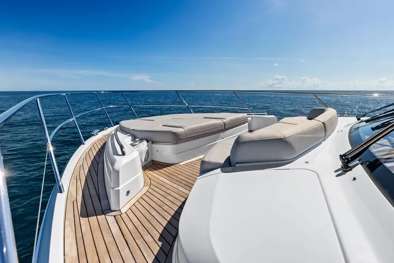 Salty Cowboy Yacht Photos Pics Luxurious 2022 Princess 55 Flybridge yacht deck with sun loungers, ocean view.