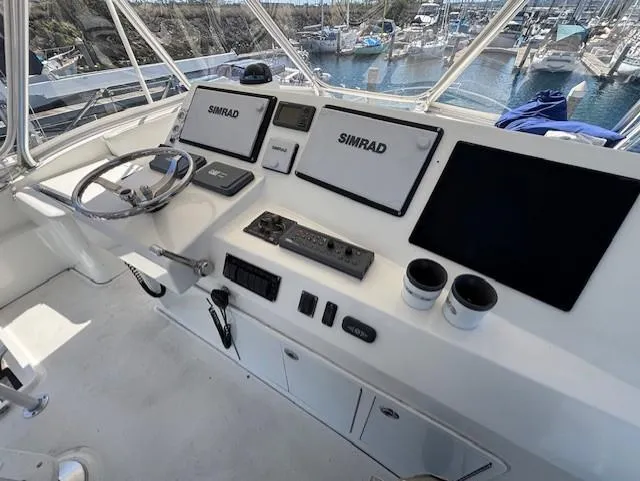  Yacht Photos Pics 2007 Jersey Cape 44 CNV helm with Simrad navigation system and marina view.