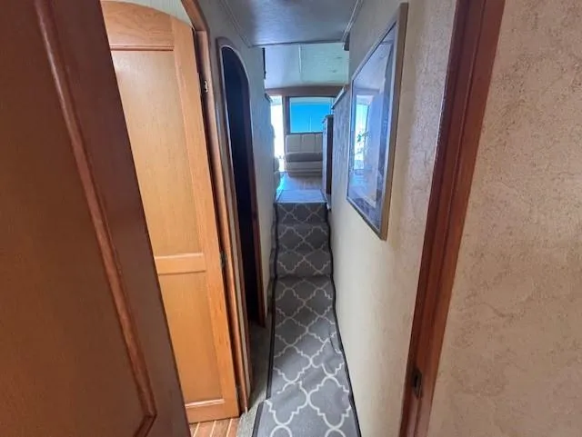  Yacht Photos Pics Narrow hallway inside 2007 Jersey Cape 44 CNV boat, featuring wooden doors and patterned carpet.
