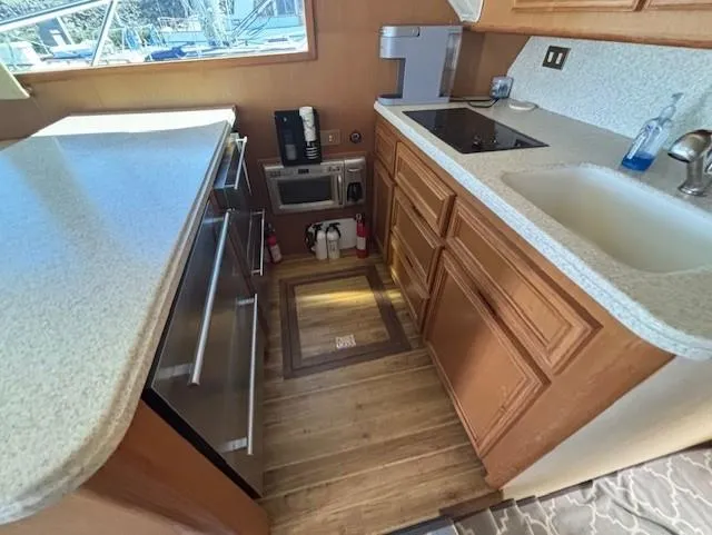  Yacht Photos Pics 2007 Jersey Cape 44 CNV yacht kitchen with modern appliances and wooden cabinetry.