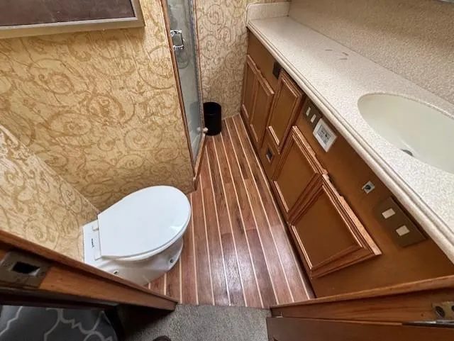  Yacht Photos Pics Bathroom interior of 2007 Jersey Cape 44 CNV with wood flooring and elegant wallpaper.