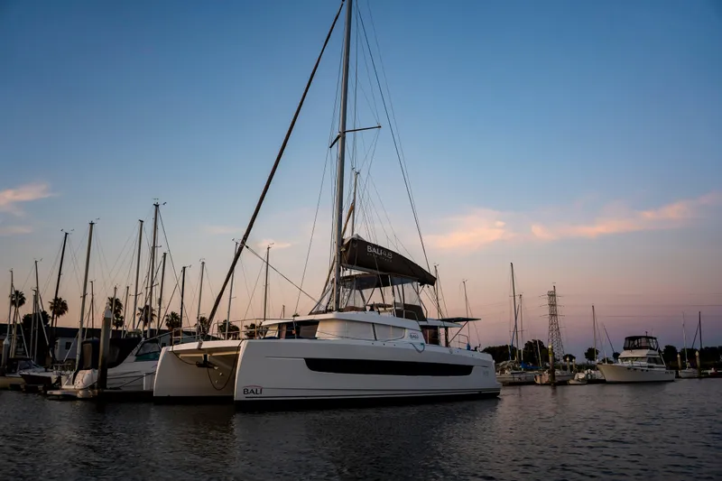 Blureverie Yacht Photos Pics 2021 Bali 4.8 catamaran docked at sunset in a serene marina setting.