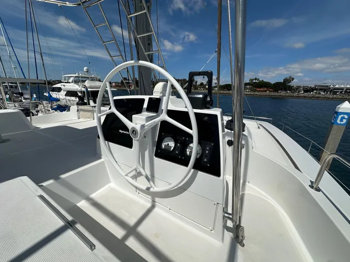 Blureverie Yacht Photos Pics Steering wheel of a 2021 Bali 4.8 yacht docked at a marina.