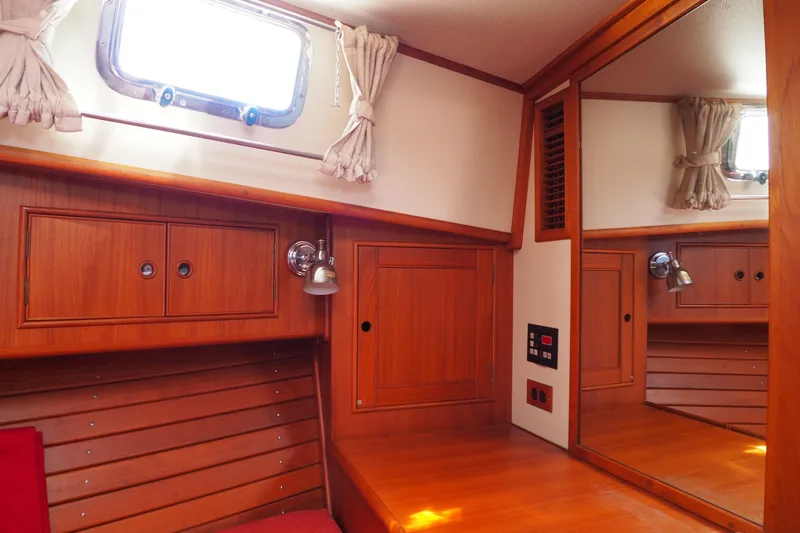 "bootlegger"-repowered Yacht Photos Pics Cozy cabin interior of 1995 Grand Banks 38 Eastbay EX with wood paneling and porthole window.