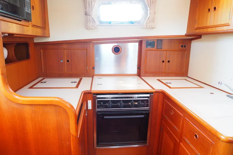 "bootlegger"-repowered Yacht Photos Pics 1995 Grand Banks 38 Eastbay EX yacht kitchen with wood cabinetry and modern appliances.
