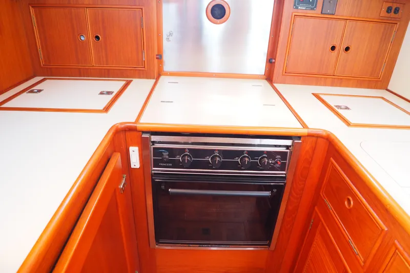 "bootlegger"-repowered Yacht Photos Pics Galley kitchen in 1995 Grand Banks 38 Eastbay EX yacht with wood cabinetry and stove.