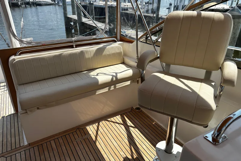 "bootlegger"-repowered Yacht Photos Pics Interior seating of 1995 Grand Banks 38 Eastbay EX yacht, featuring beige upholstery and wooden flooring.