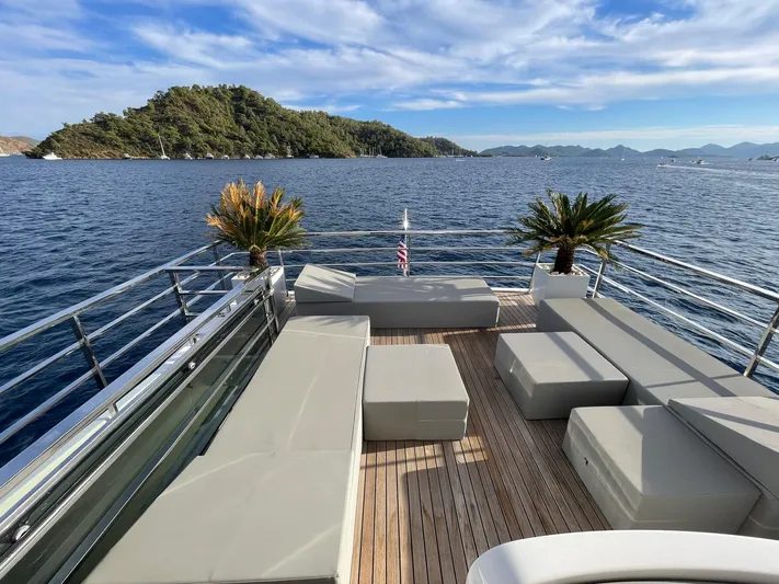 Tmr Yacht Photos Pics Luxurious yacht deck with seating, ocean view, and island backdrop, Custom 84 model, 2018.