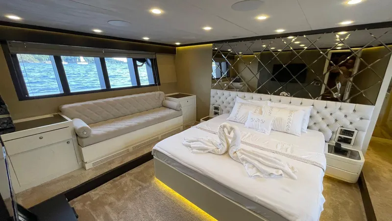 Tmr Yacht Photos Pics Luxurious yacht bedroom with elegant decor, featuring a plush bed and scenic window views.
