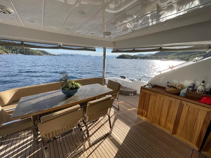 Tmr Yacht Photos Pics Luxurious yacht deck with dining area, overlooking serene ocean view, Custom 84 model, 2018.