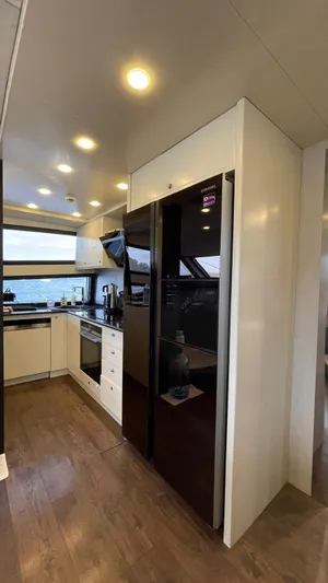 Tmr Yacht Photos Pics Modern yacht kitchen with sleek appliances and wood flooring, Custom 84 model, 2018.