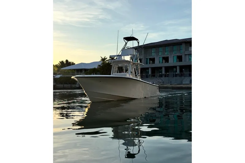  Yacht Photos Pics 2015 SeaVee 390Z boat on calm water at sunset near modern buildings.