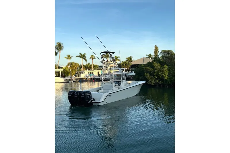  Yacht Photos Pics 2015 SeaVee 390Z boat with triple engines on a calm waterway, surrounded by palm trees.