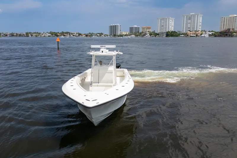  Yacht Photos Pics 2015 SeaVee 39Z boat cruising on a calm waterway with city skyline in background.