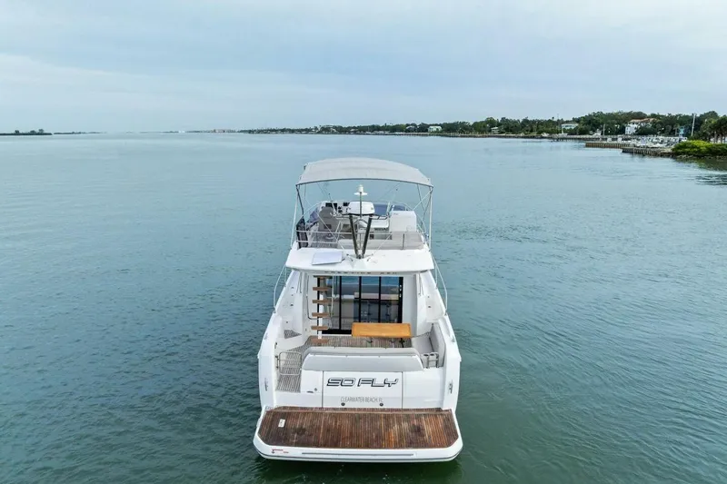 So Fly Yacht Photos Pics 2022 Prestige 420 yacht on calm water, rear view with open deck and canopy.