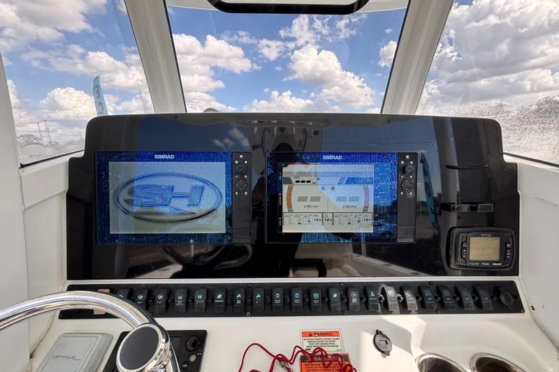  Yacht Photos Pics 2018 Sea Hunt Gamefish 30 dashboard with Simrad displays and steering wheel under cloudy sky.