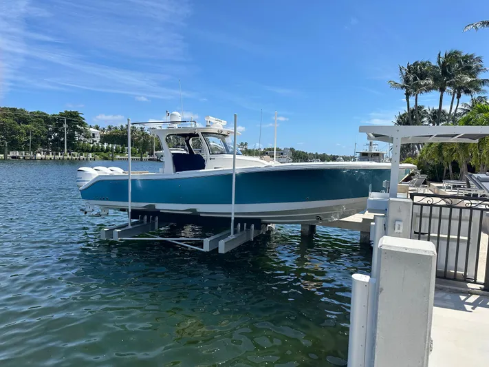 Perfection Yacht Photos Pics 2020 Edgewater 370 CC boat docked on a lift by a waterfront.
