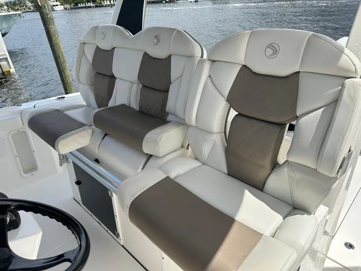 Perfection Yacht Photos Pics 2020 Edgewater 370 CC boat seats with beige and white upholstery by the water.