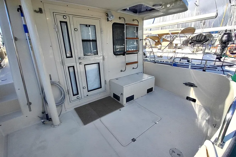 Green Goose Yacht Photos Pics 1998 Nordic Tug 42 boat deck with door, storage, and railing in marina setting.