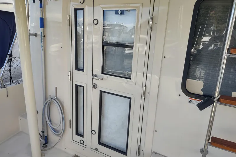 Green Goose Yacht Photos Pics 1998 Nordic Tug 42 boat door with windows and nautical equipment.