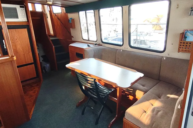 Green Goose Yacht Photos Pics Interior of a 1998 Nordic Tug 42, featuring a cozy dining area with large windows.