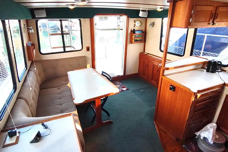 Green Goose Yacht Photos Pics Interior of a 1998 Nordic Tug 42, featuring a cozy dining area and wooden cabinetry.
