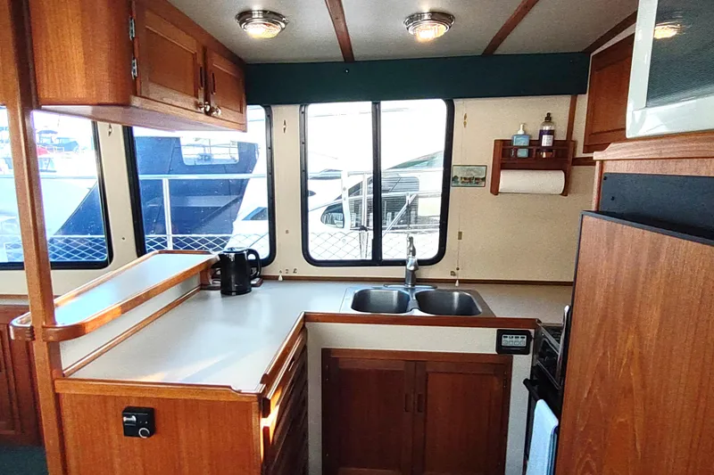 Green Goose Yacht Photos Pics 1998 Nordic Tug 42 interior kitchen with wooden cabinetry and dual sink.