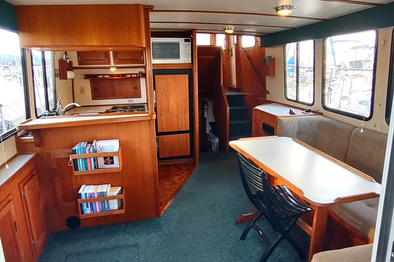 Green Goose Yacht Photos Pics Interior of a 1998 Nordic Tug 42, featuring a cozy dining area and kitchenette.