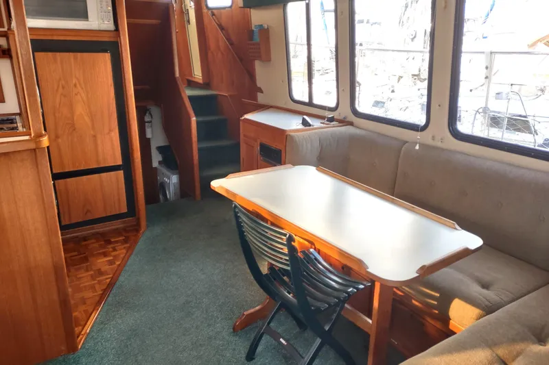 Green Goose Yacht Photos Pics Interior of 1998 Nordic Tug 42 with dining area and wooden cabinetry.