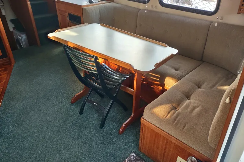 Green Goose Yacht Photos Pics Cozy interior of 1998 Nordic Tug 42 with dining table and cushioned seating.