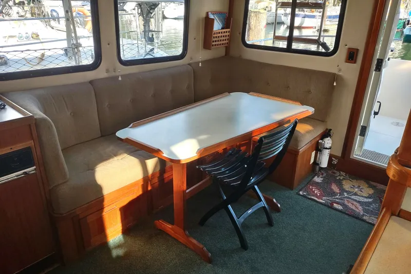 Green Goose Yacht Photos Pics Cozy dining area in a 1998 Nordic Tug 42 boat with a table and seating.