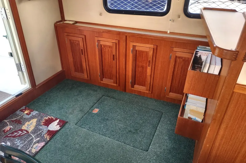 Green Goose Yacht Photos Pics Interior of 1998 Nordic Tug 42 with wooden cabinets and green carpet flooring.