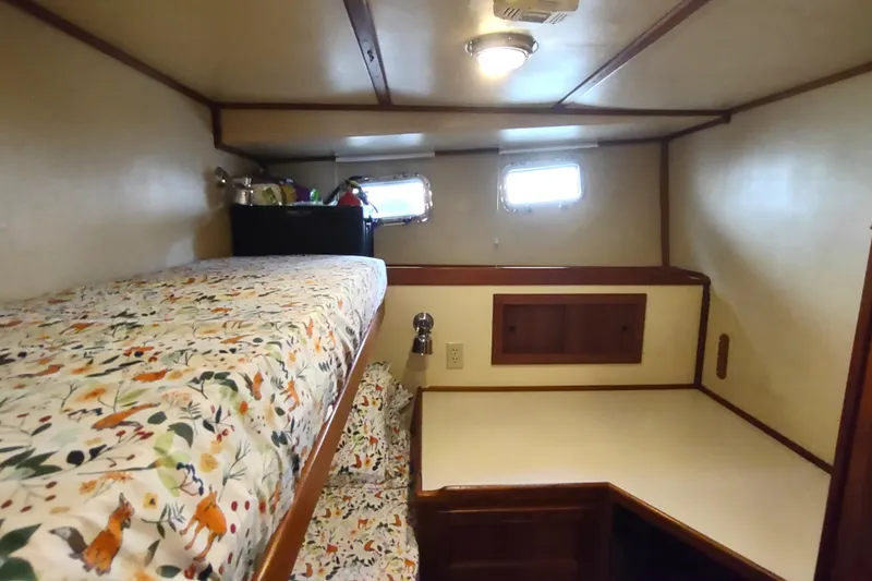 Green Goose Yacht Photos Pics Cozy cabin interior of 1998 Nordic Tug 42 with bunk bed and porthole windows.