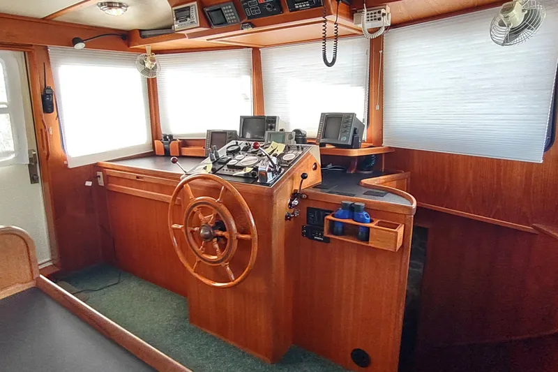Green Goose Yacht Photos Pics 1998 Nordic Tug 42 helm with wooden wheel, navigation instruments, and cozy interior.