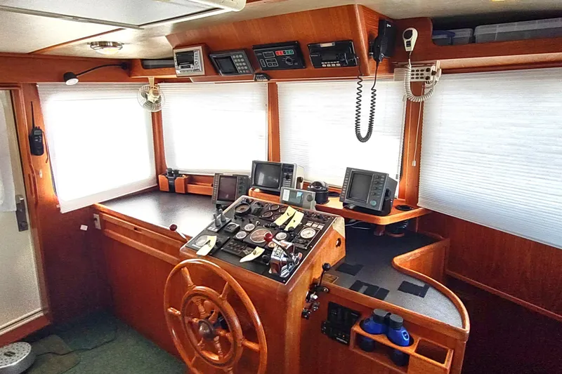 Green Goose Yacht Photos Pics Pilothouse of a 1998 Nordic Tug 42 with navigation equipment and wooden helm.