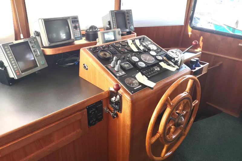 Green Goose Yacht Photos Pics Bridge of a 1998 Nordic Tug 42 with navigation equipment and wooden steering wheel.