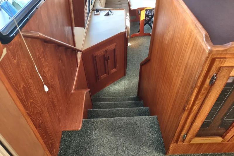 Green Goose Yacht Photos Pics Interior stairs of 1998 Nordic Tug 42 with wooden paneling and carpeted steps.