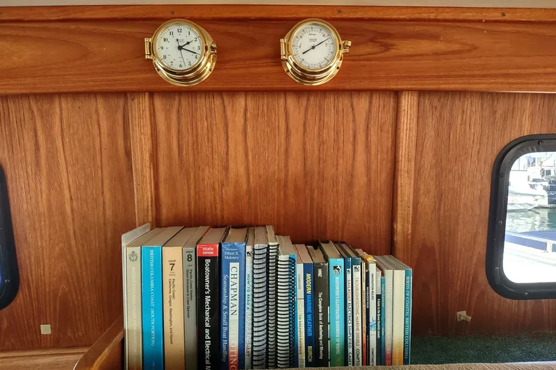 Green Goose Yacht Photos Pics Bookshelf on 1998 Nordic Tug 42 with nautical books and brass instruments.
